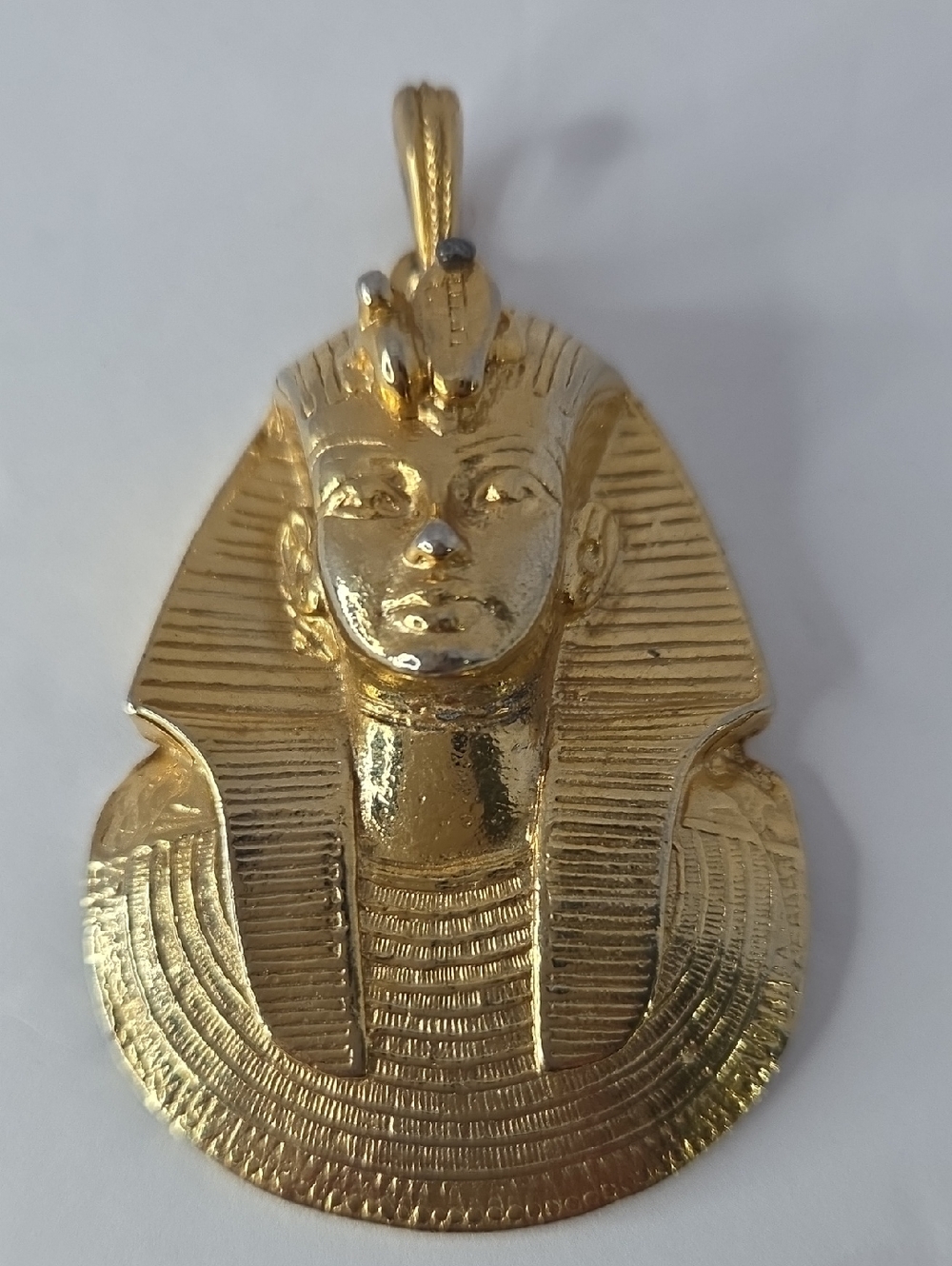 Gold-tone Egyptian Revival style pendant depicting the portrait mask of King Tut
